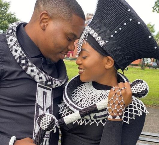 Xhosa couple in traditional xhosa black and white accessories embracing each other